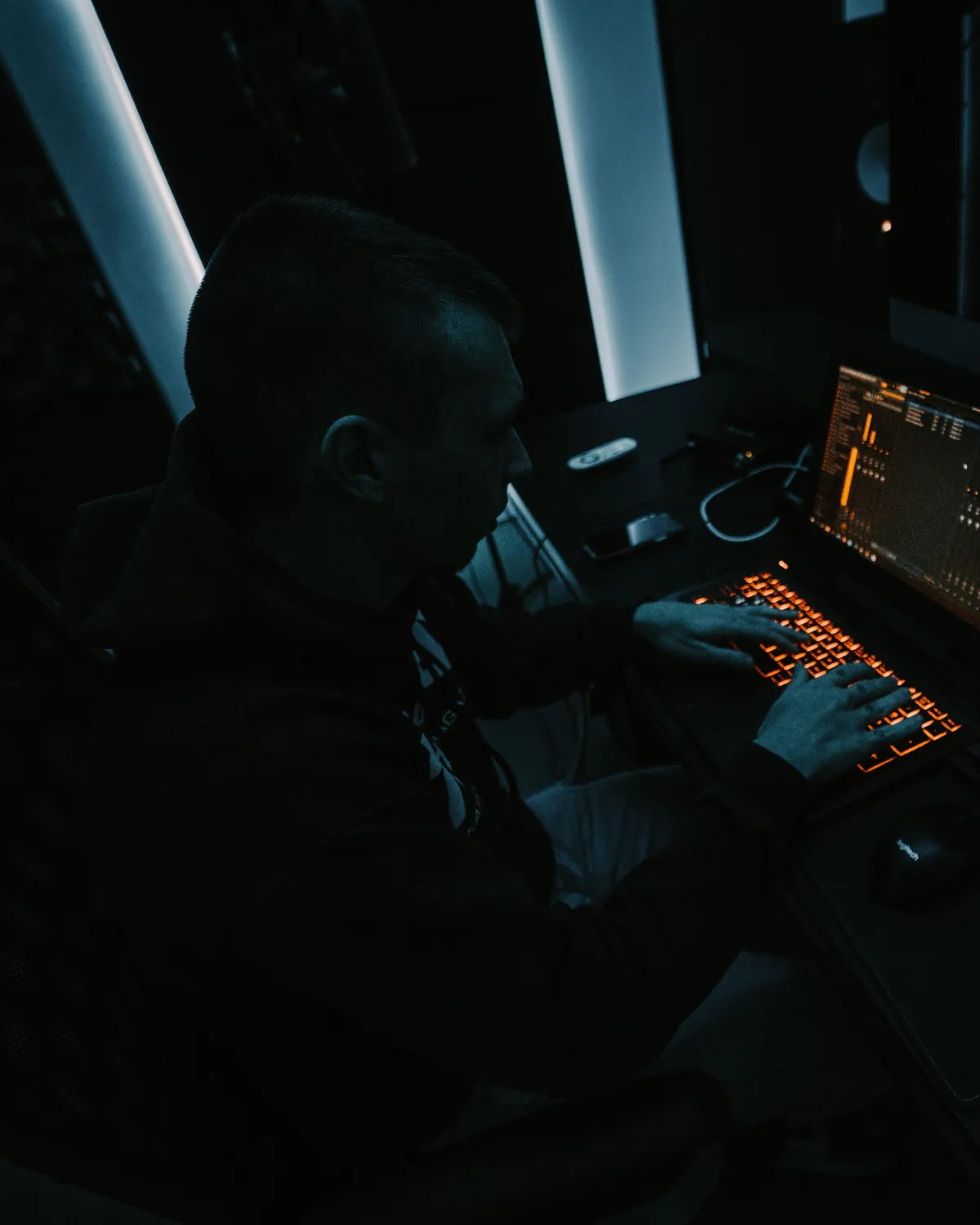 Productor trabajando en una consola de estudio con poca luz